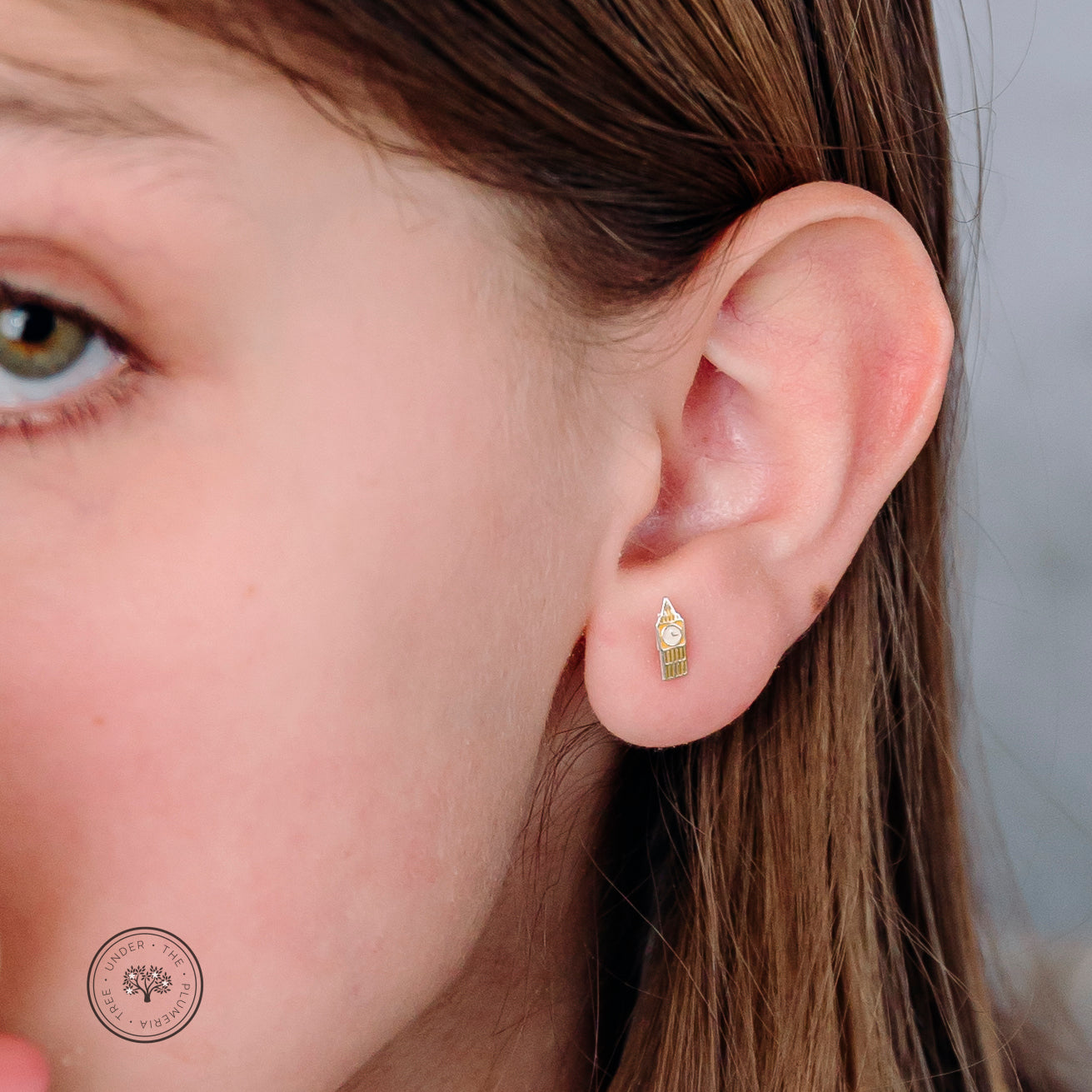 Girl modeling the clock tower Big Ben earrings so the size can be shown on a child