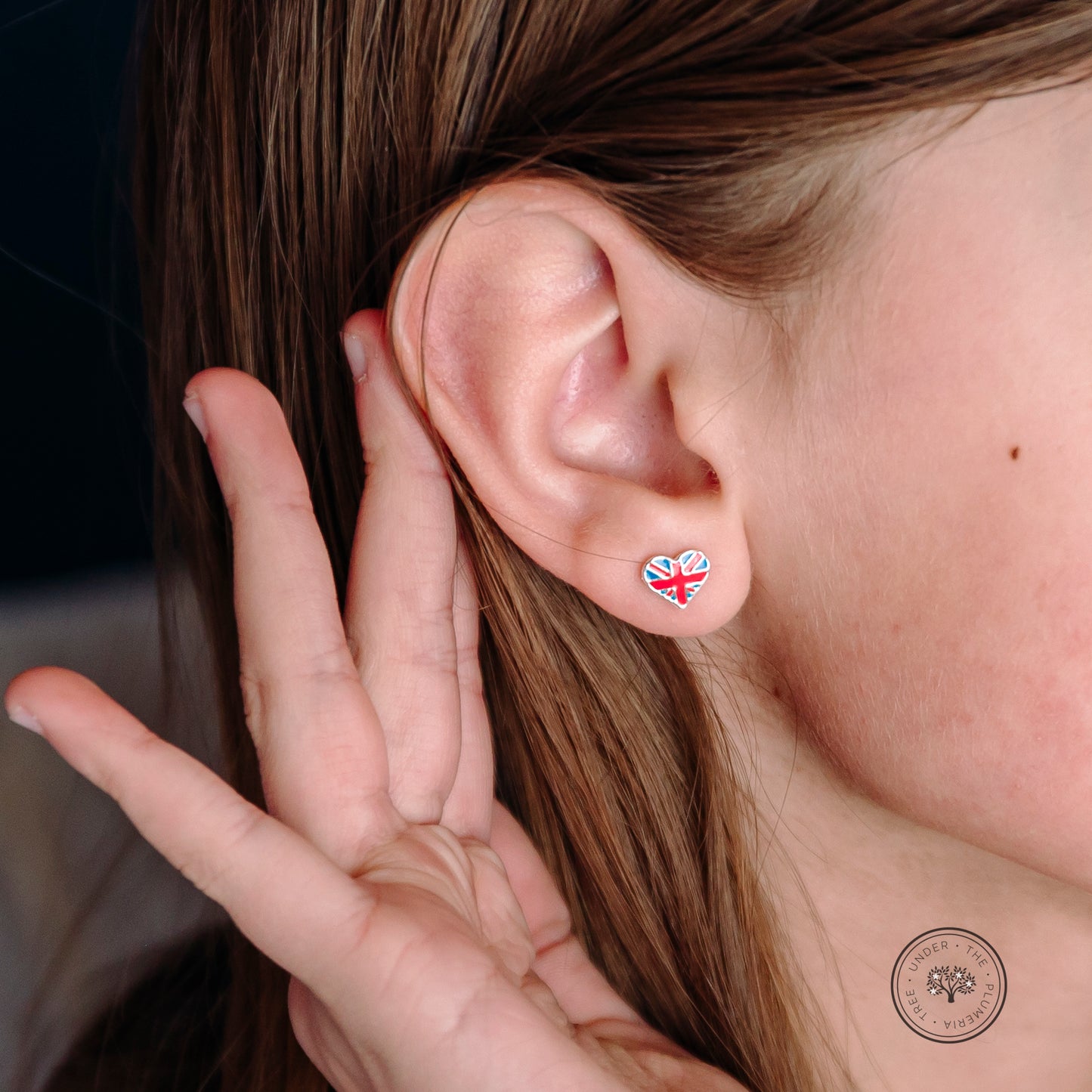 Great Britain heart earring modeled for sizing accuracy.